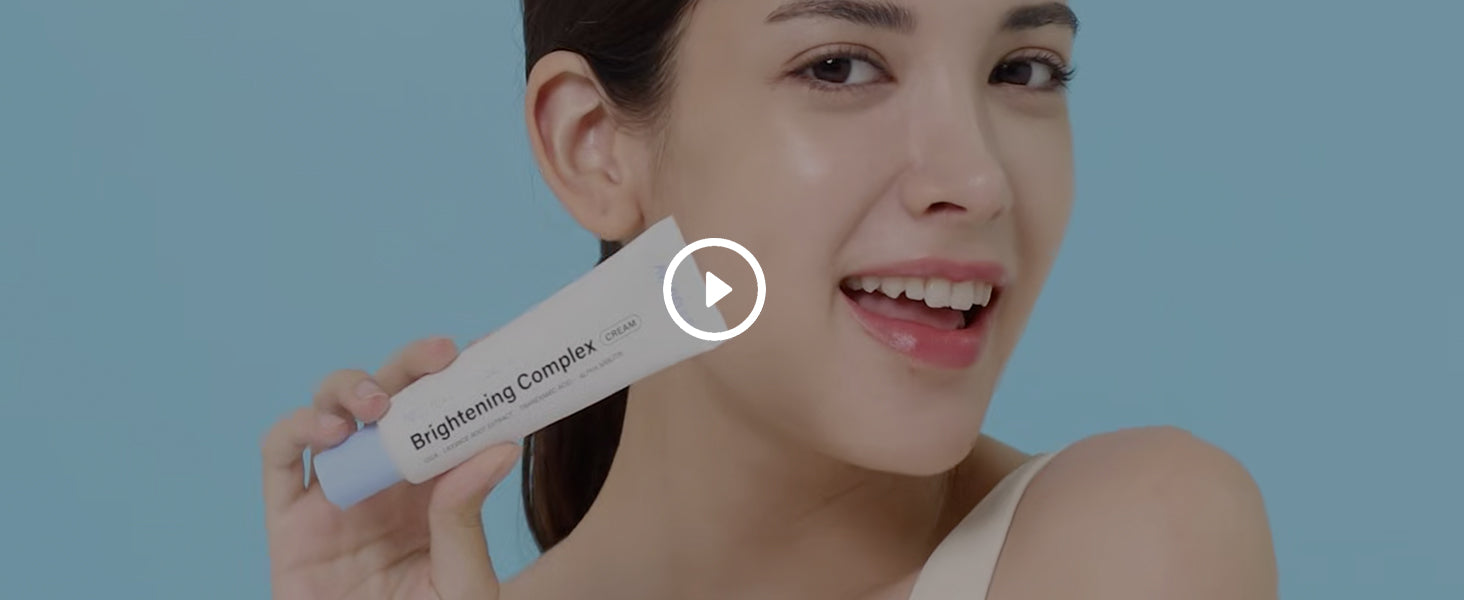 A smiling woman holding Avarelle's 10% Niacinamide Brightening Complex.